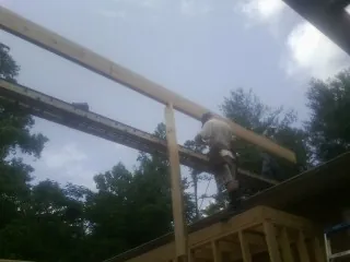 Carpenter setting a ridge beam over a new addition frame — Ice Dam Removal by Roofing Brothers in New Durham