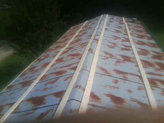 Rusted metal roof panels with new wood purlins before replacement — Storm Damage Roof Repair in New Durham by Roofing Brothers
