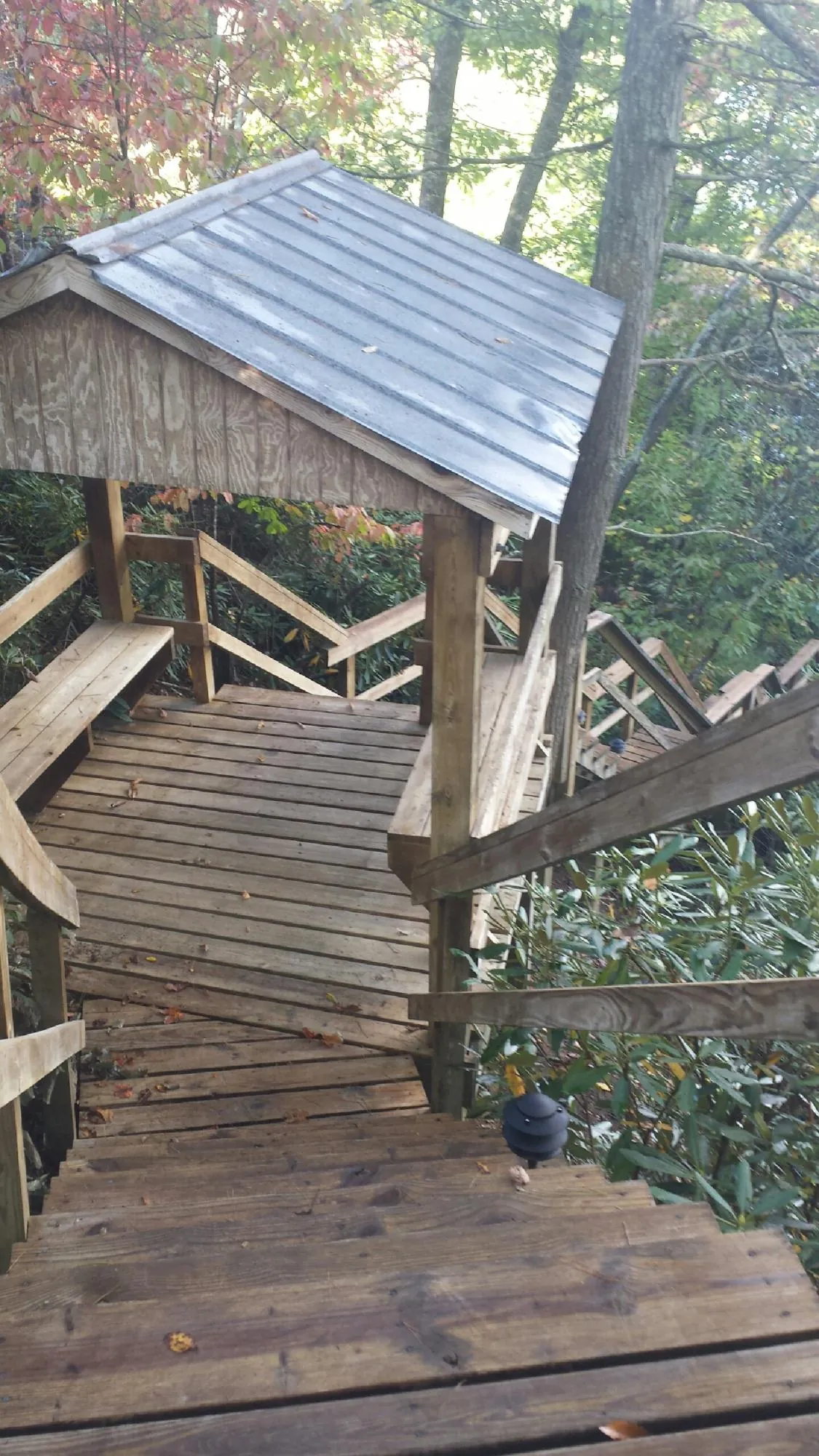 Metal roofed shelter over wooden steps on a wooded walkway — Skylight Repair & Installation work by our crew in New Durham