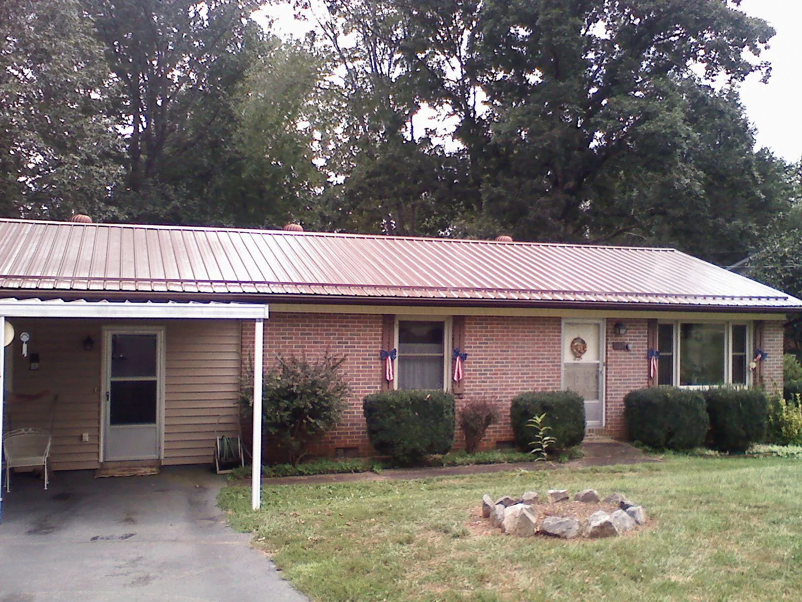 Bronze metal roof and carport on a brick ranch home — Roof Repair work by our crew in New Durham